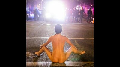 Голая Афина занимается йогой перед ощетинившимися полицейскими. Портленд, США. 2020г.